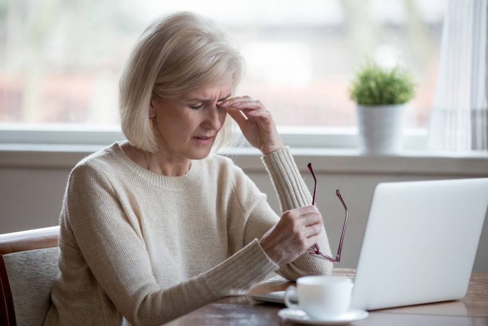 vrouw moedeloos achter laptop