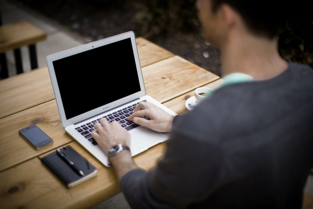 Man aan het typen op laptop